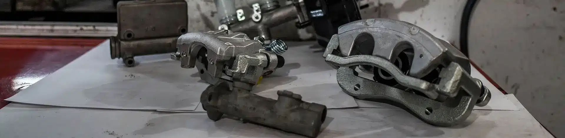 Brake calipers, pads and metal brake components on a workbench