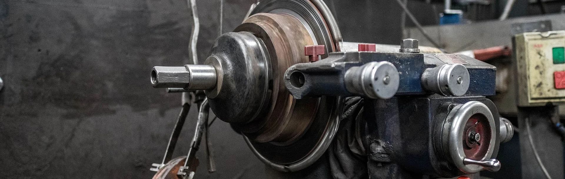A metal brake disc mounted on a workshop machining lathe