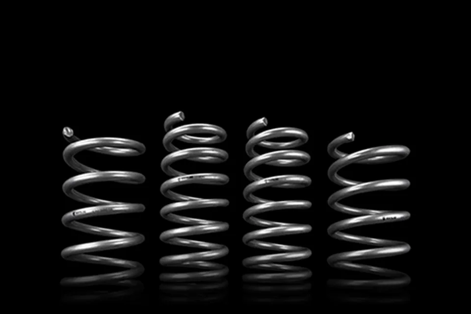Four metal coil springs standing against a black background